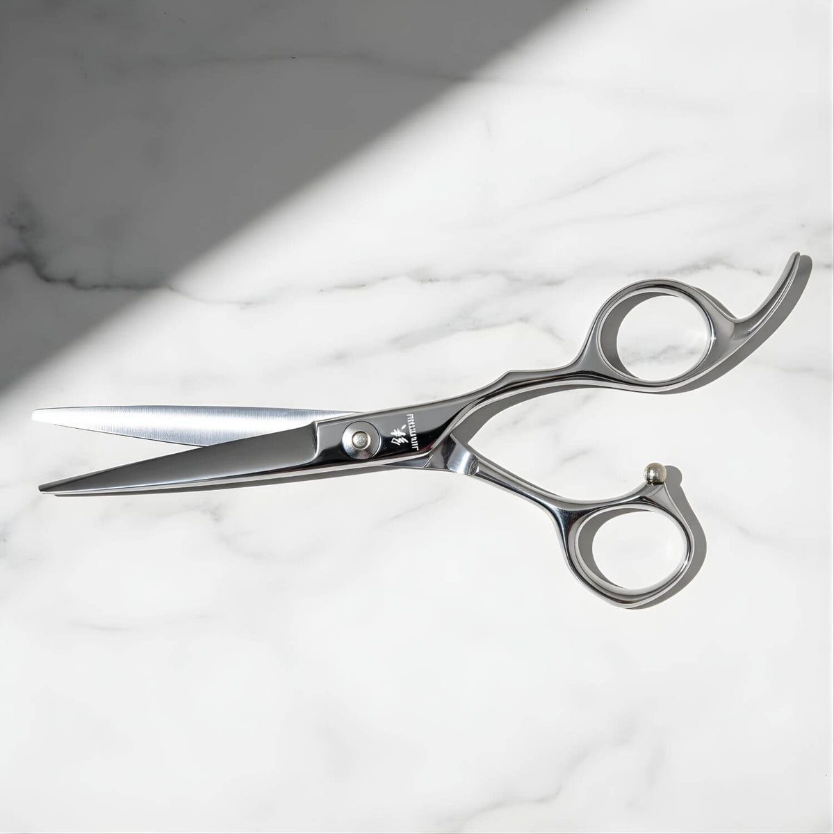 Ciseaux de coupe Offset Juntetsu VG10 posés sur un marbre blanc