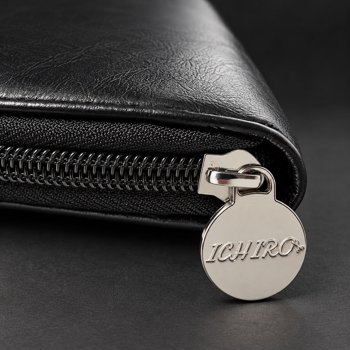 Tirette de zip en métal gravée du logo Ichiro sur l’étui de voyage noir