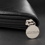 Tirette de zip en métal gravée du logo Ichiro sur l’étui de voyage noir